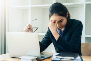 Defensor público adjunto cansado frente a una computadora