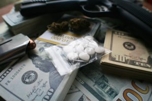 A gun, a bag of drugs, and cash to represent a NRS 207.400 violation.