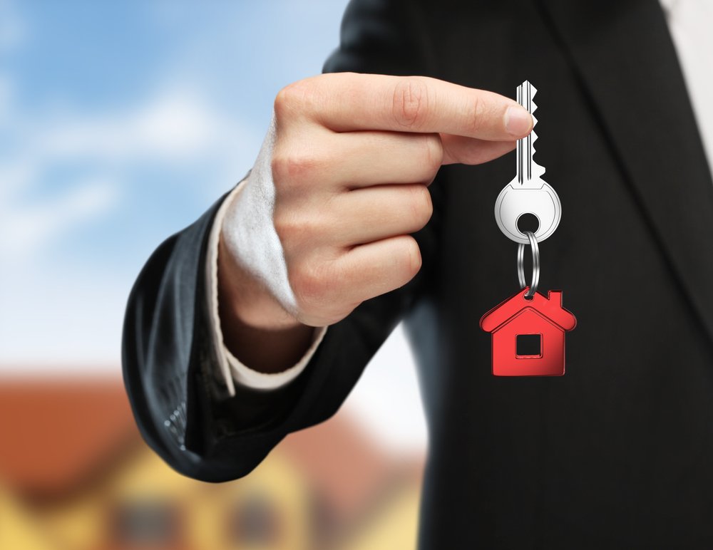 Un agente de bienes raíces sosteniendo una llave.