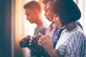 Personas orando durante un servicio religioso