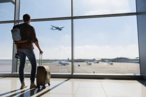 A young man watching airplanes from the terminal.