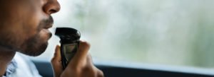 Hombre con una licencia restringida soplando en un IID en su automóvil