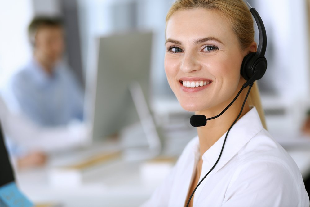 Smiling receptionist answering phone call.