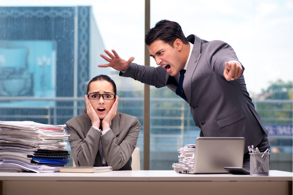 Angry boss screaming at female employee.