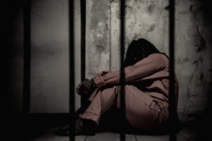 Woman prisoner behind bars