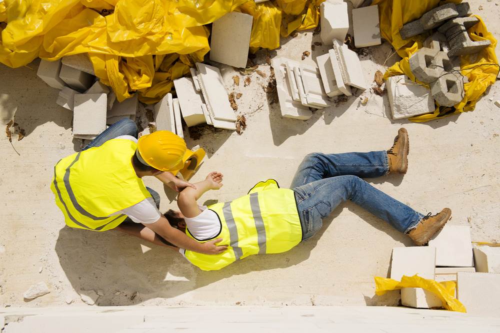 Un trabajador de la construcción herido yaciente en el suelo.