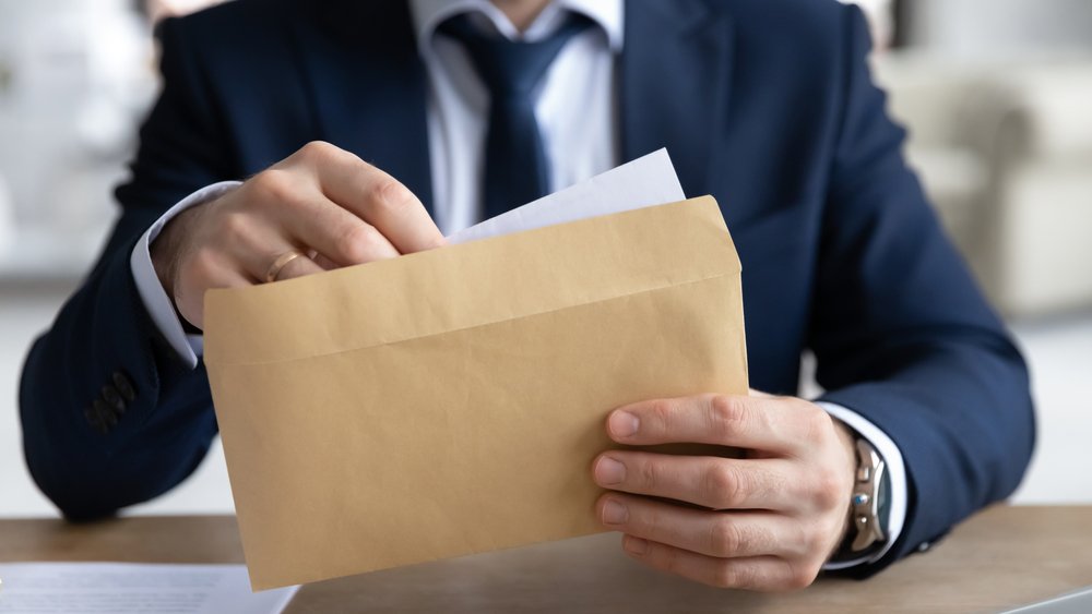 An attorney enclosing a personal injury demand letter into an envelope.