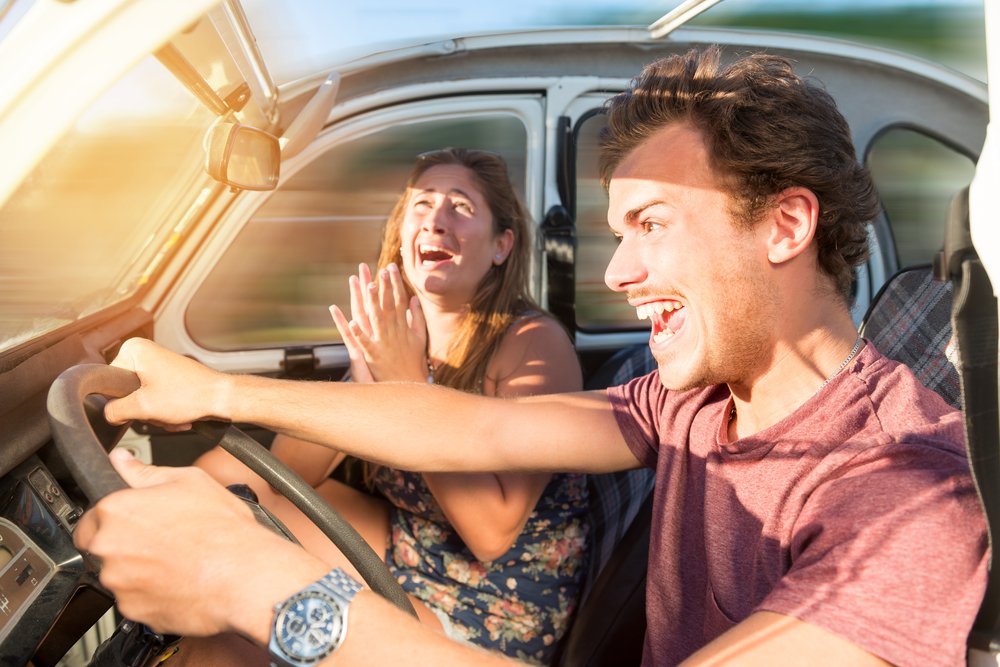 A man driving wildly as his passenger pleads with him to slow down.