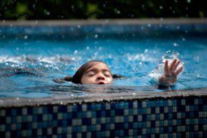 Child struggling to stay afloat in pool