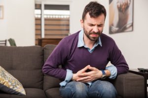 Food poisoning victim on couch in great pain