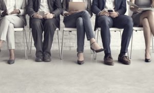 Foto de solicitantes de empleo con trajes esperando a ser llamados para una entrevista