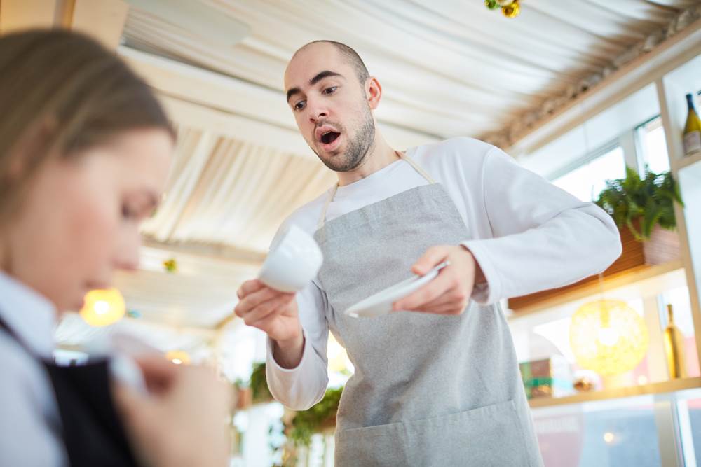 Waiter spilling hot drink on customer.