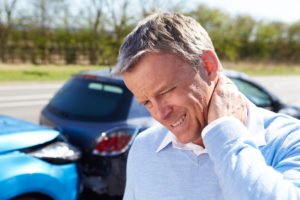 Man holding his neck in pain after a ride share car accident.