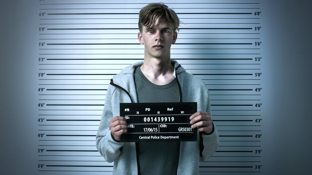 A mugshot of a young man with a bruised face.