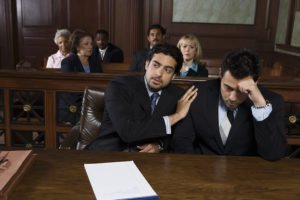 Public defender comforting client in courtroom