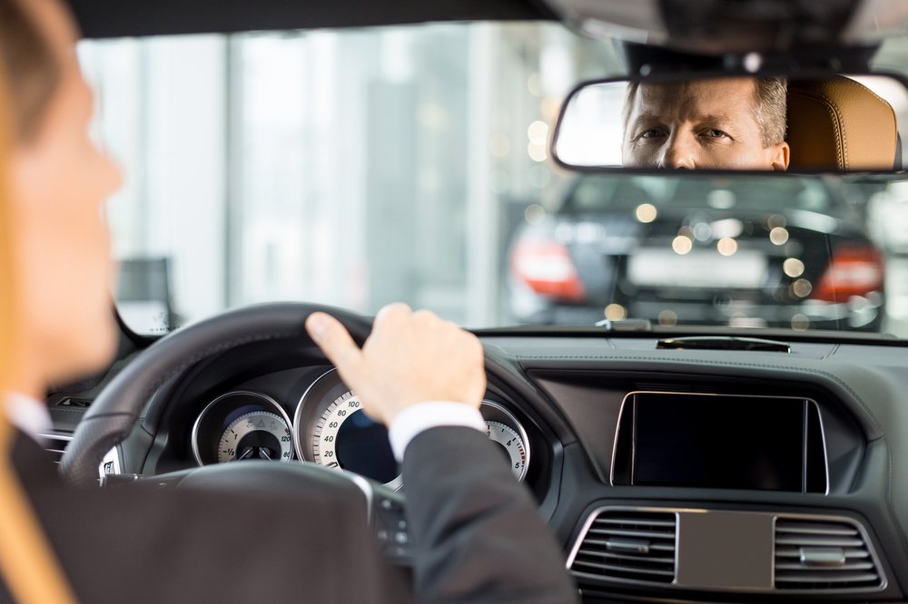 Uber driver looking at rear view mirror.