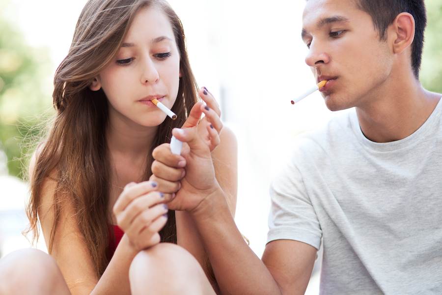 Teenagers smoking, who cannot legally buy cigarettes