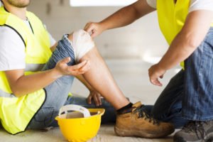 Trabajador de construcción lesionado con casco en el suelo