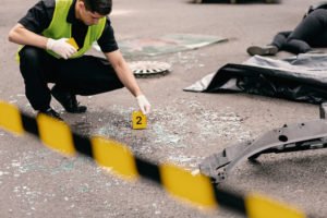 Aftermath of deadly car crash on the street with police cordoning off scene