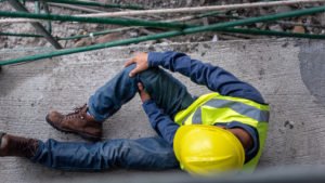 Trabajador de construcción en el suelo después de caer