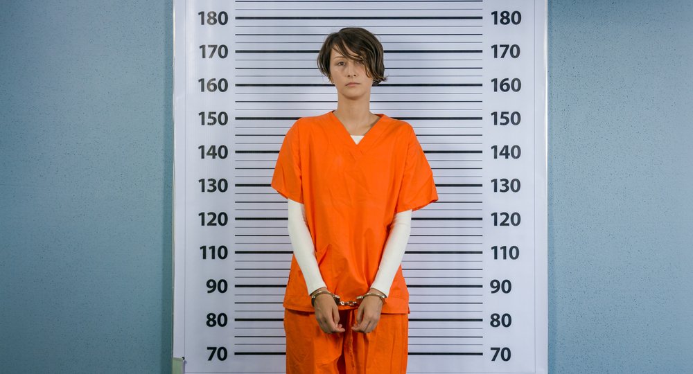 A mugshot of a woman wearing prison garb.