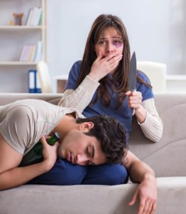 Víctima de violencia doméstica sosteniendo un cuchillo después de apuñalar a su pareja abusiva en defensa propia