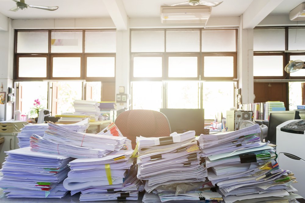 A public defender's desk with piles of documents on top.
