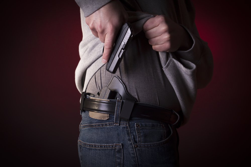 A man pulling his gun out of its holster.