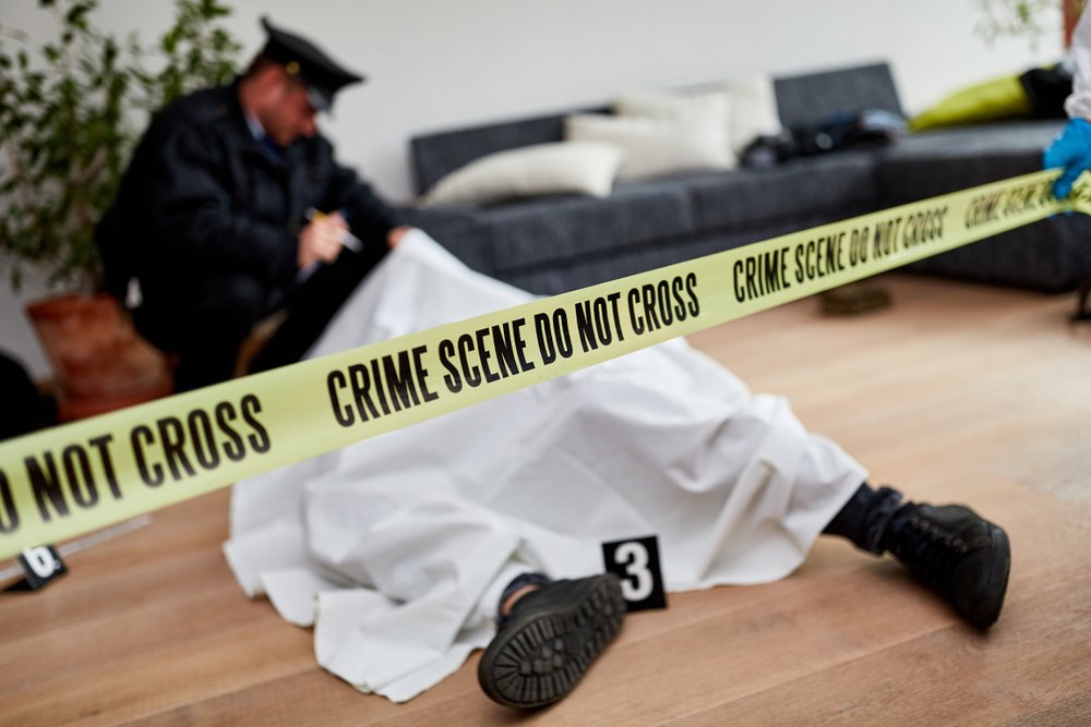 A dead police officer blanketed at a crime scene.