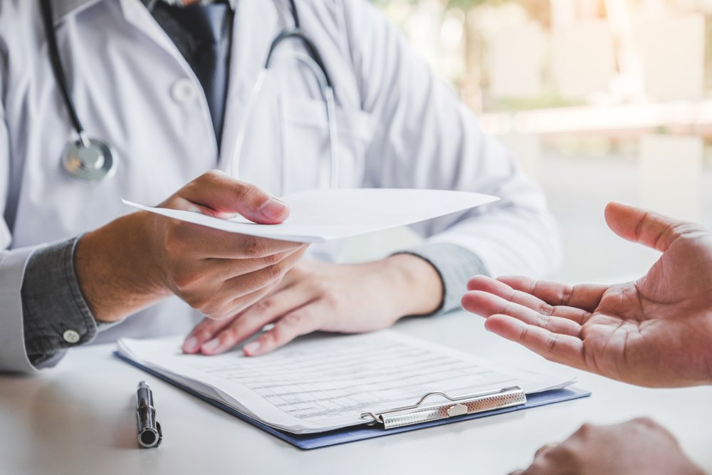 A doctor handing over a prescription note.