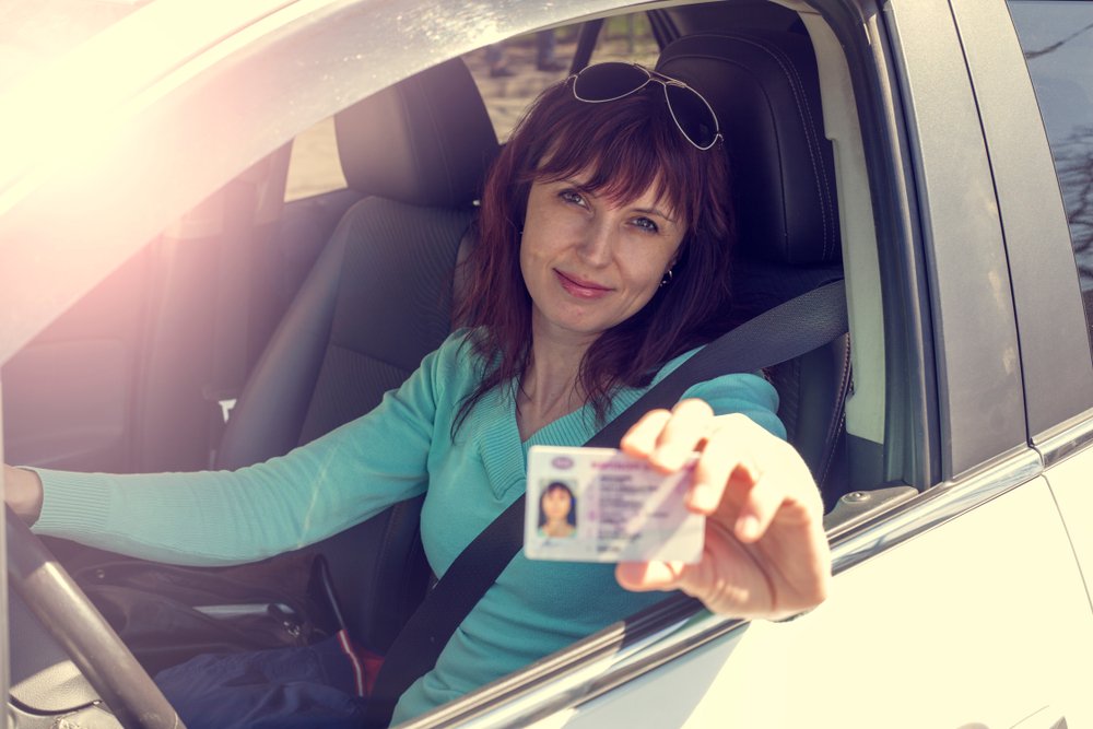 A woman proudly showing off her reinstated driver's license.