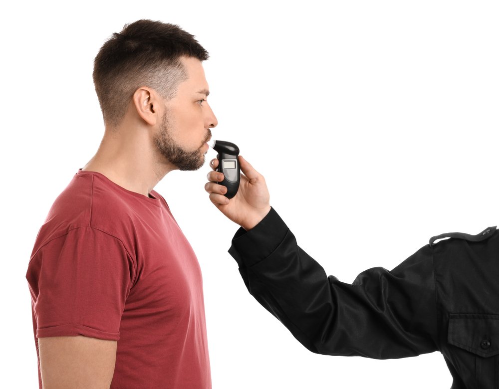 A man blowing into a breathalyzer.