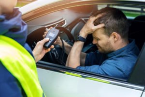 Man holding his head in frustration after blowing over the legal limit.