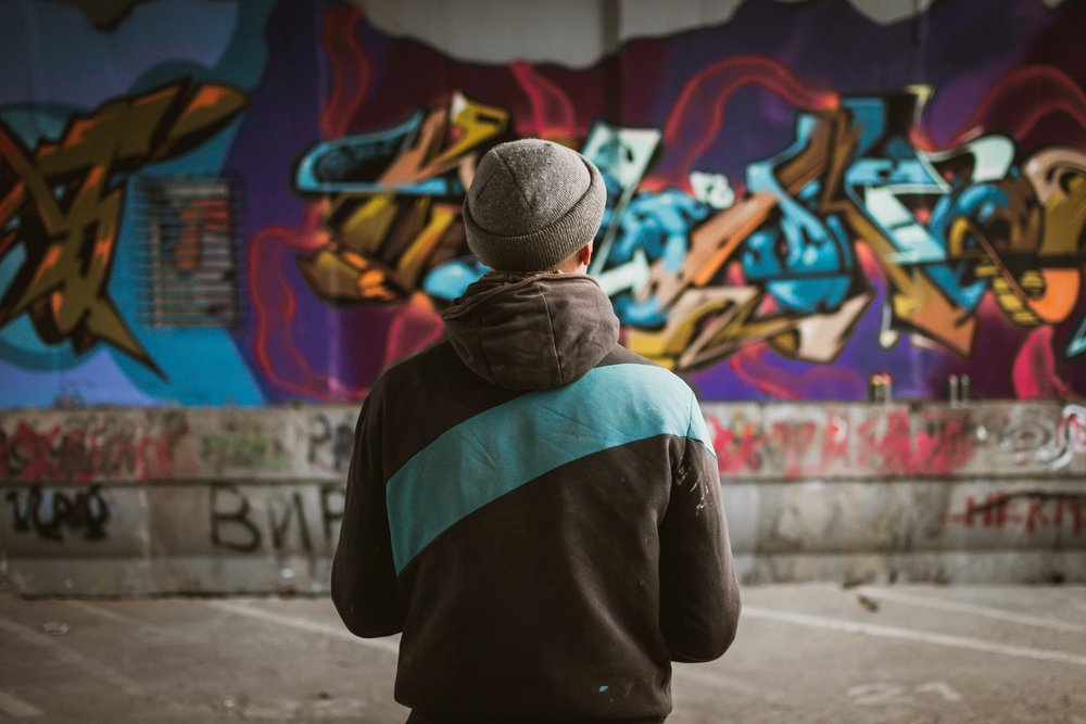 A man standing in front of his graffiti on a wall, as an example of a NRS 206.330 violation in Nevada.