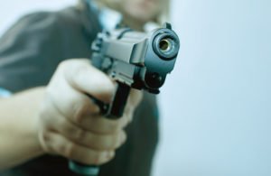 A person pointing the gun at something or someone.