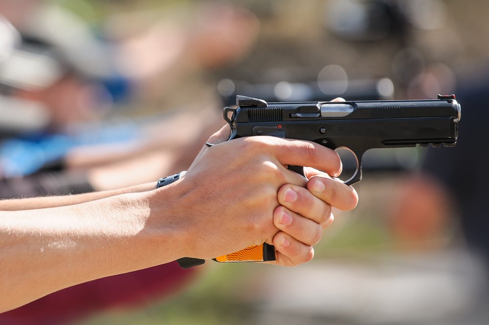 Gun aficionados pointing their guns at targets.