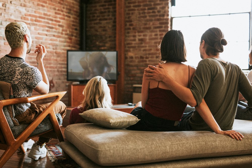 Hip apartment dwellers watching a movie together.