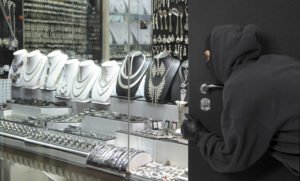 A burglar breaking into a jewelry store.