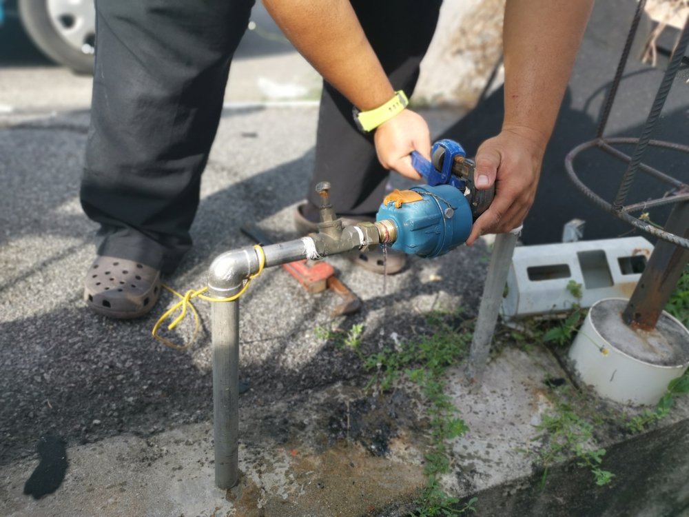 Un hombre desconectando una línea de agua.