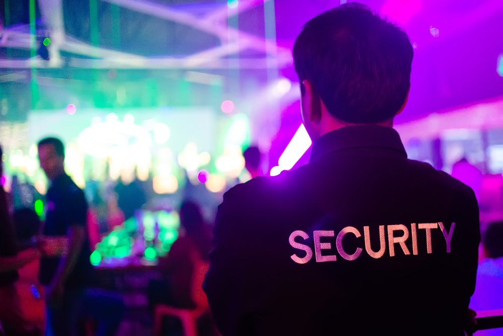 Un guardia de seguridad de un club nocturno escaneando la escena.