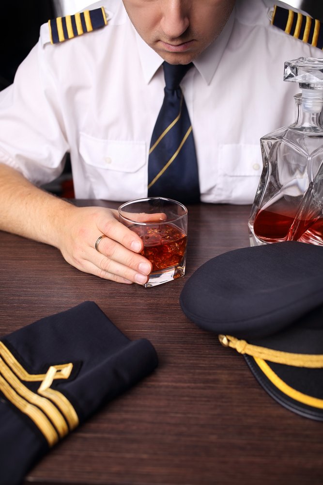A pilot having a stiff drink before a flight.