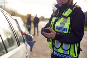 A police officer checking out a cellphone.