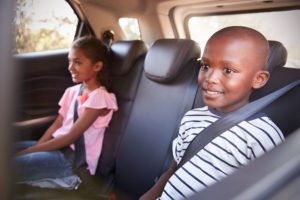 Two eight-year old passengers with seat belts on in accordance with VC 27360.5. 