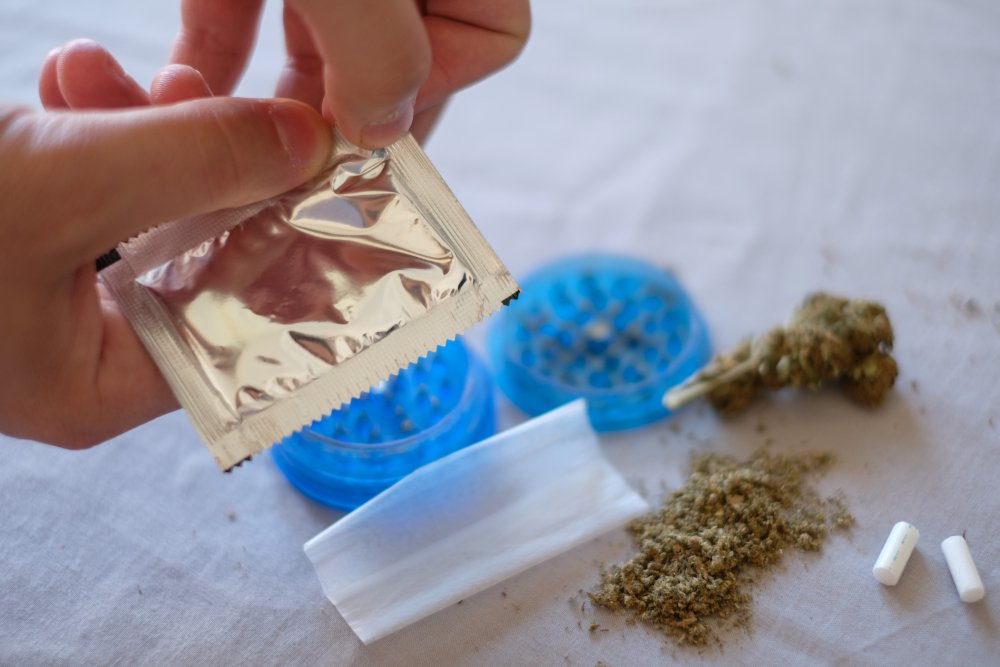 Person unpacking some synthetic marijuana into a rolling paper.
