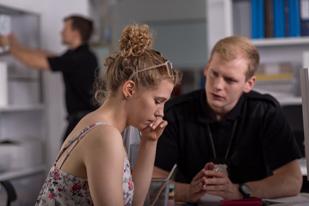 A suspect pondering what to do while a police officer asks her questions.