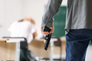 A man holding a gun and making terrorist threats at a school.