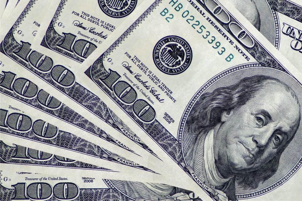 Multiple hundred dollar bills featuring Benjamin Franklin.