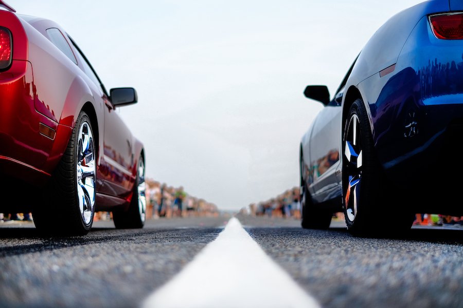 Two cars on the street about to drag race 