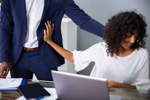 Woman pushing away a male co-worker making inappropriate sexual advances
