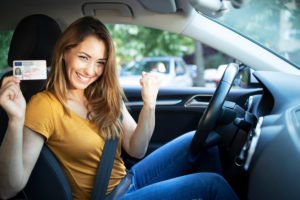 Woman driver holding up driver's license